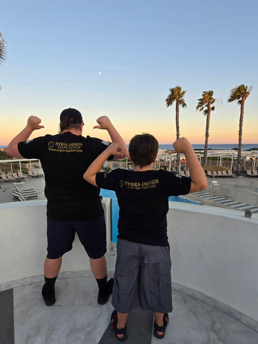 Zwei Personen in schwarzen Nyrra-Design T-Shirts mit Rücken-Print,
Sonnenuntergang an einem Pool mit Palmen – Nyrra-Design Merch im Alltag