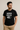 Mann im schwarzen T-Shirt mit weißem Aufdruck „Nerd Mode On“, steht seitlich und blickt nach links; humorvolles, personalisierbares Design für Nerds, Gamer und Technikfans.