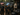 Actionreiche Paintball- und Lasertag-Szene mit dunklen Merch-Produkten von Nyrra Merch System. Die Szene zeigt Teamshirts und Merchandise für Freizeitparks, Paintball-Hallen und Lasertag-Arenen.