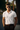 Mann trägt weißes NYRRA-DESIGN Premium-Piqué-Poloshirt mit goldener Stickerei, eleganter Look
