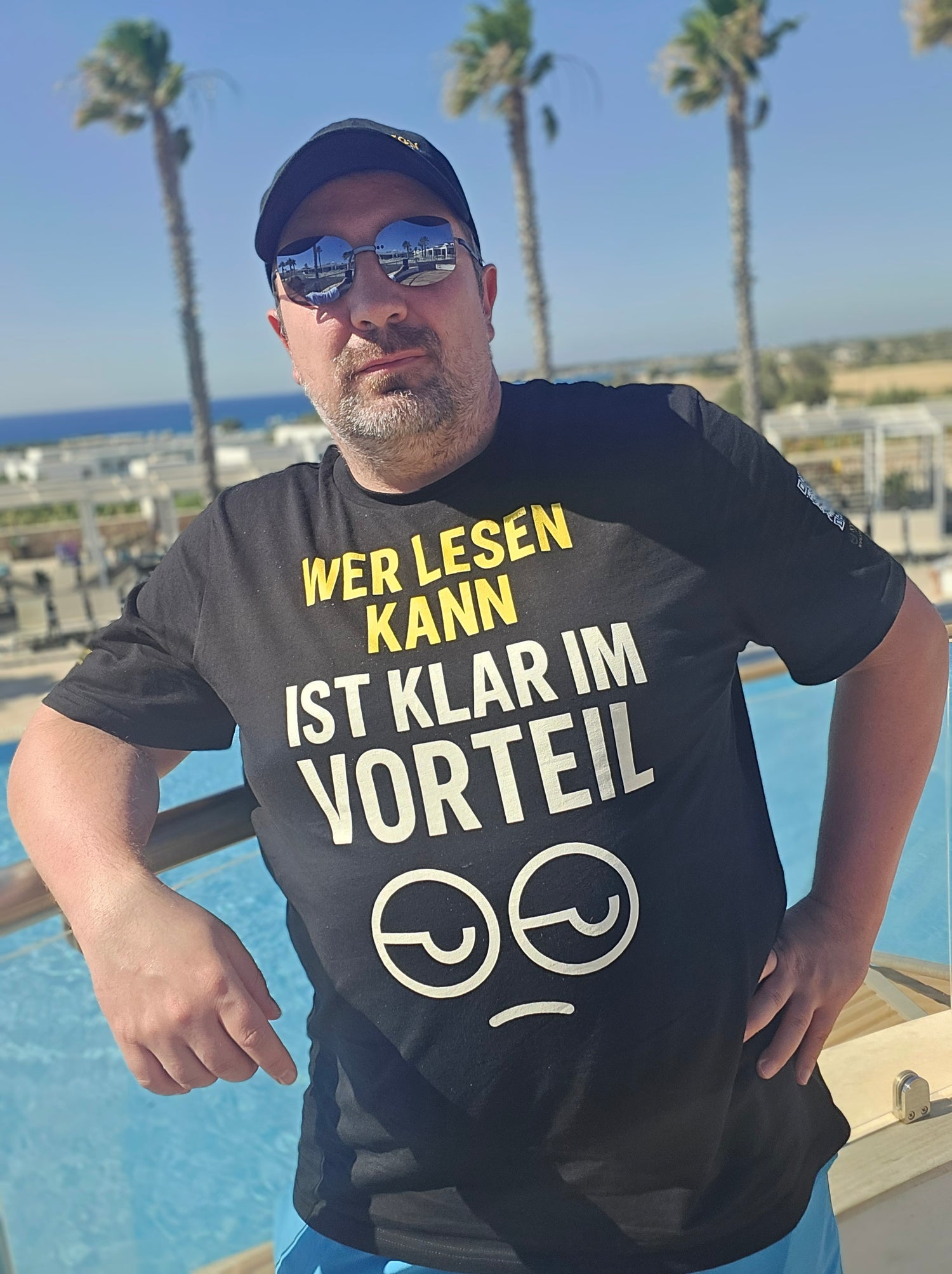Bio-T-Shirt von Nyrra-Design mit Spruch: Wer lesen kann, ist klar im Vorteil – Sommerbild mit Sonnenbrille & Palmen